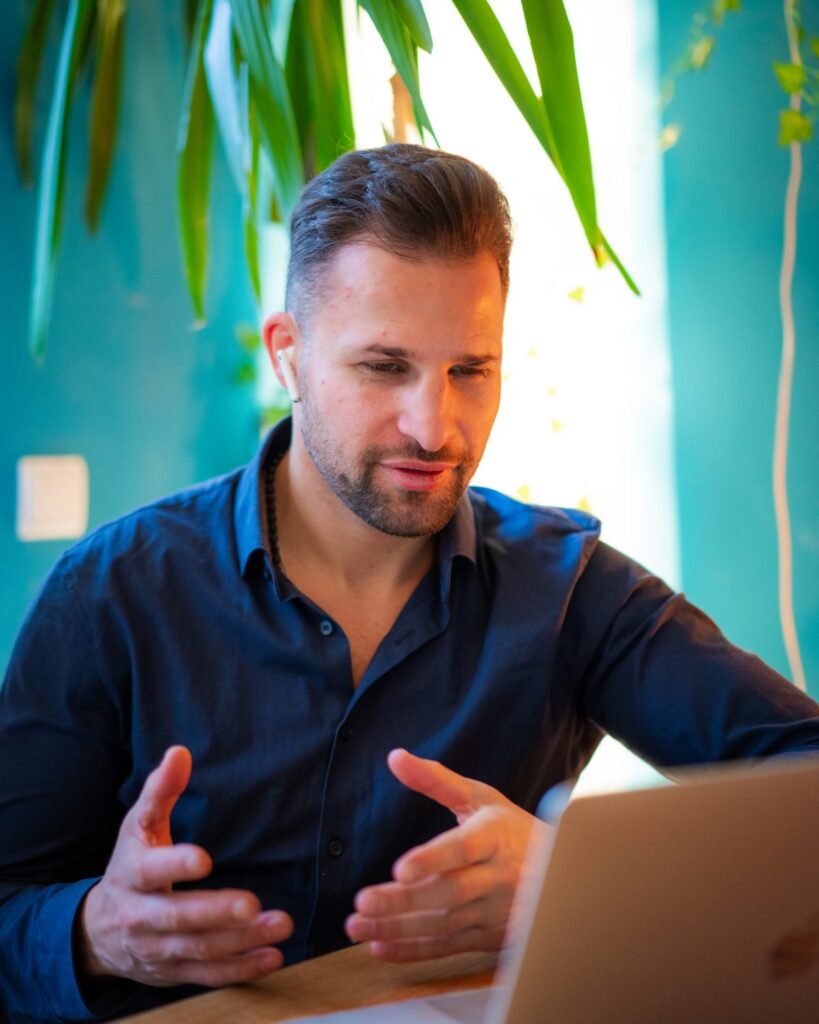 Max Baumert betreut einen Kunden online per Videocall am Laptop