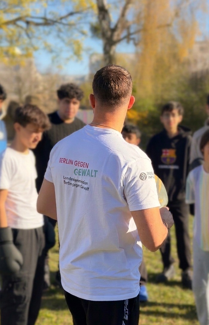 Max Baumert erklärt einer Gruppe Jugendlicher beim Training im Freien