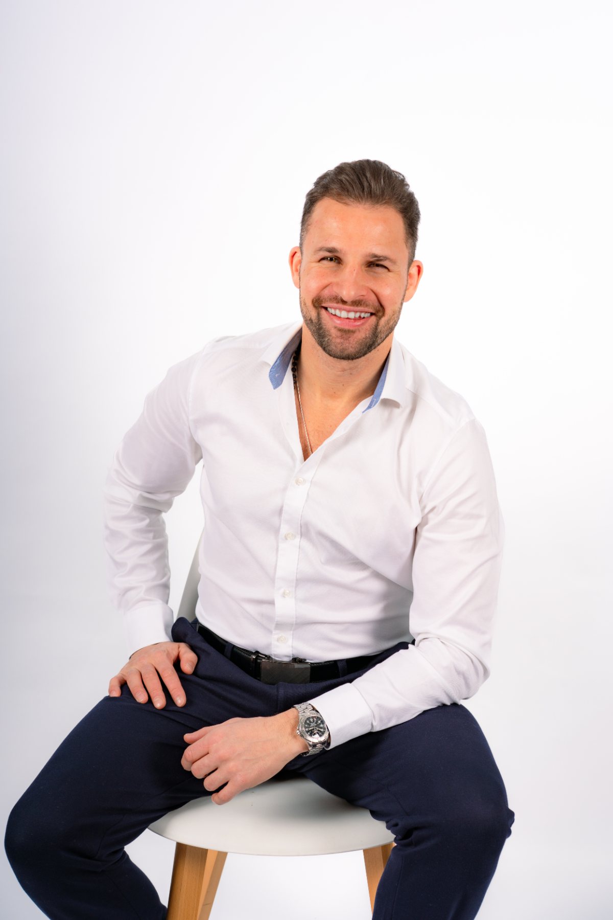Max Baumert, Personal Trainer und Coach in Berlin, lächelnd im weißen Hemd